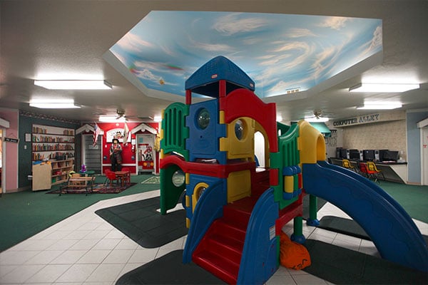 Colorful plastic playhouse with slides indoor at a Preschool & Daycare Serving Hesperia, CA