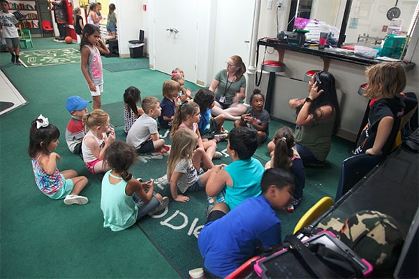 Teachers with group of multi ethnic young little kids gather around at a Preschool & Daycare Serving Hesperia, CA