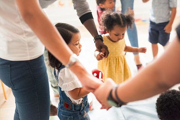 parents and little young kids holding each others hands at a Preschool & Daycare Serving Hesperia, CA