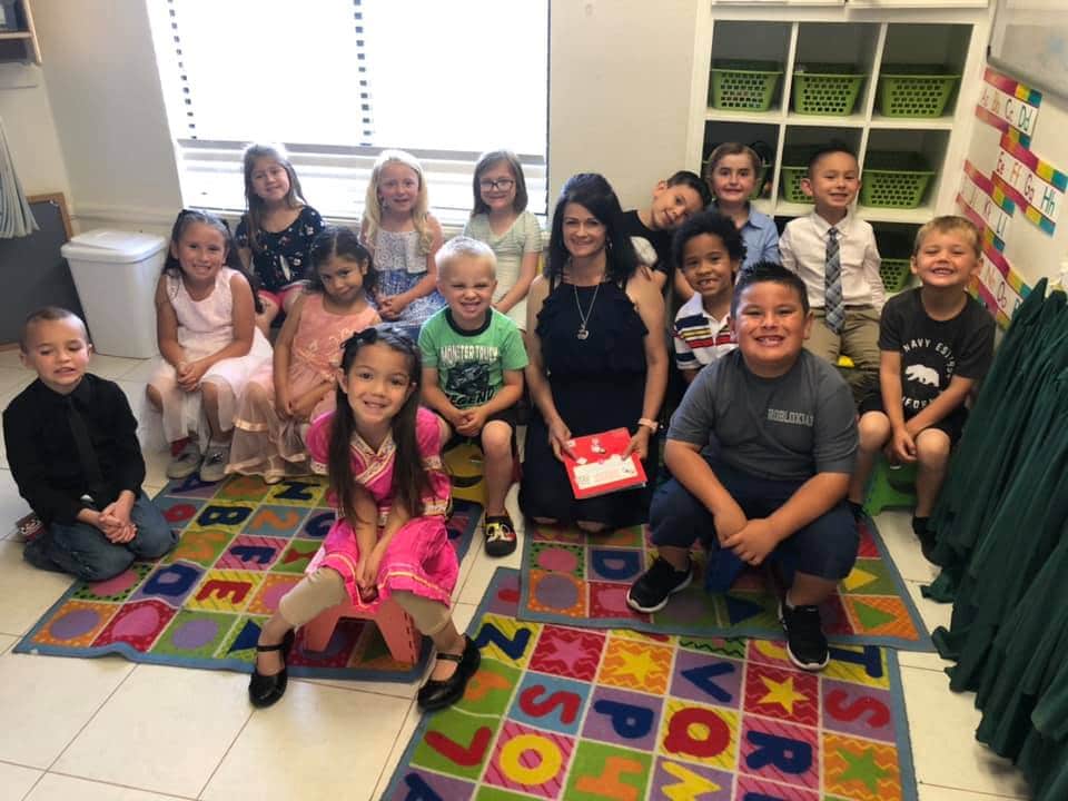 Group of children smiling with their teacher at a Preschool & Daycare Serving Hesperia, CA