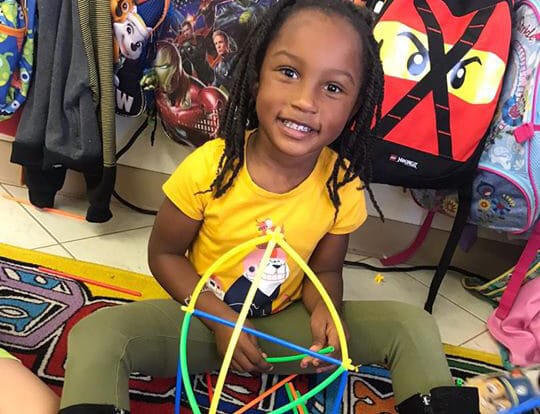 happy african american girl playing colorful stick building blocks at a Preschool & Daycare Serving Hesperia, CA