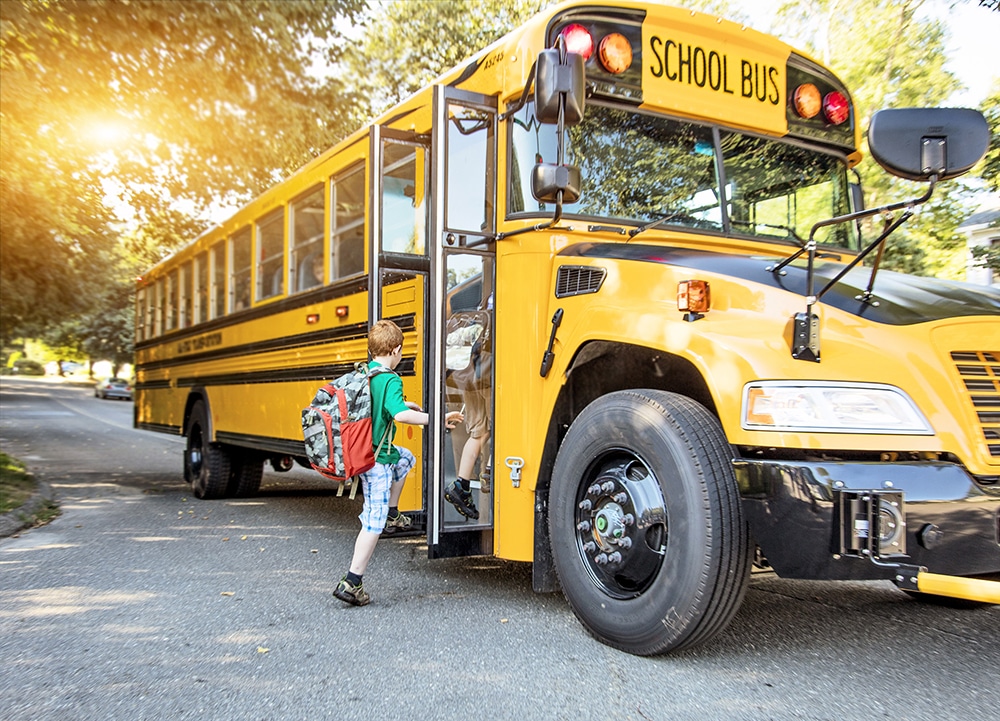 A group of young children getting on the schoolbus at a Preschool & Daycare Serving Hesperia, CA