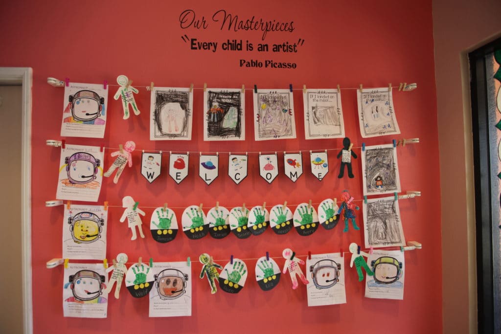 Artistic design of wall art with drawing of children of astronaut helmets and human like figure cutouts at a Preschool & Daycare Serving Hesperia, CA