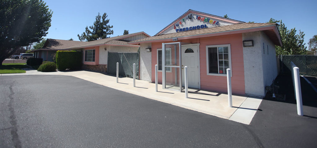 Just 4 Toddler Preschool pink house, white door, grey gate outside view at a Preschool & Daycare Serving Hesperia, CA