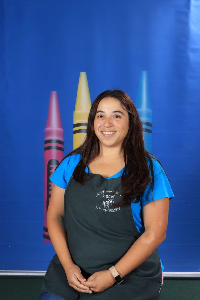 Ms_Tracey happy preschool teacher with a crayon and blue background at a Preschool & Daycare Serving Hesperia, CA